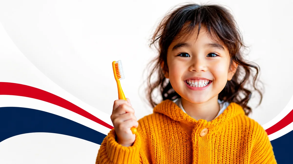 A smiling child holding a toothbrush at Streetsboro Dental Partners